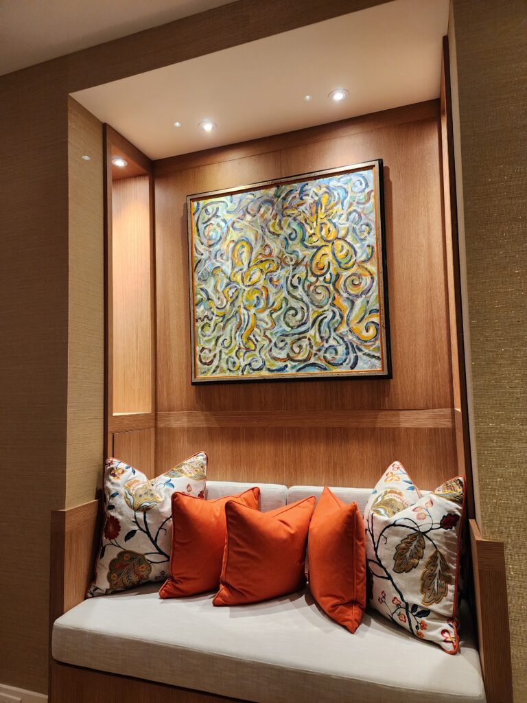 Custom millwork seating nook with tailored textiles, decorative pillows, and warm interior lighting by Magy Interiors