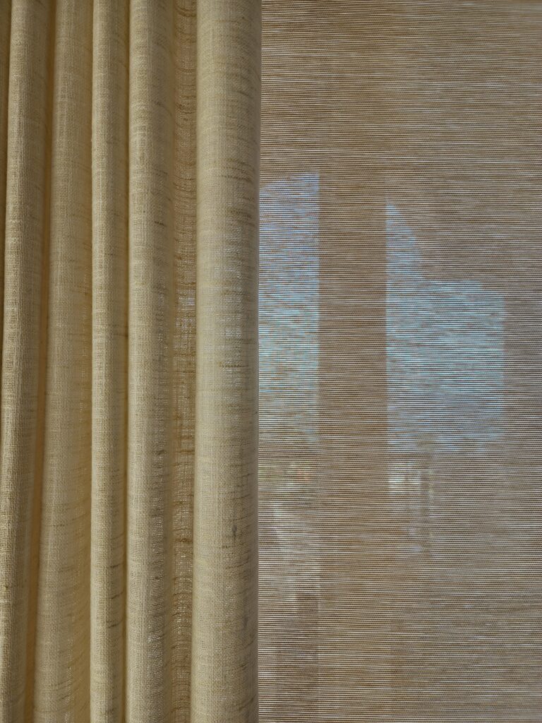 Layered custom soft drapery and woven window shades by Magy Interiors