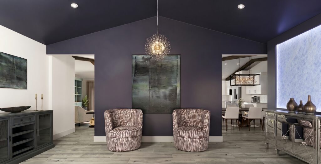 Grand primary foyer interior featuring a dark accent wall, backlit stone panel, and curated seating by Magy Interiors