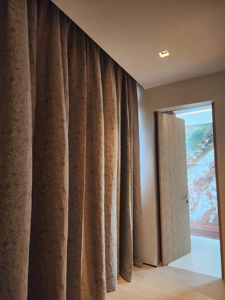 Custom floor-to-ceiling motorized curtains made with luxury fabric for light control and privacy.